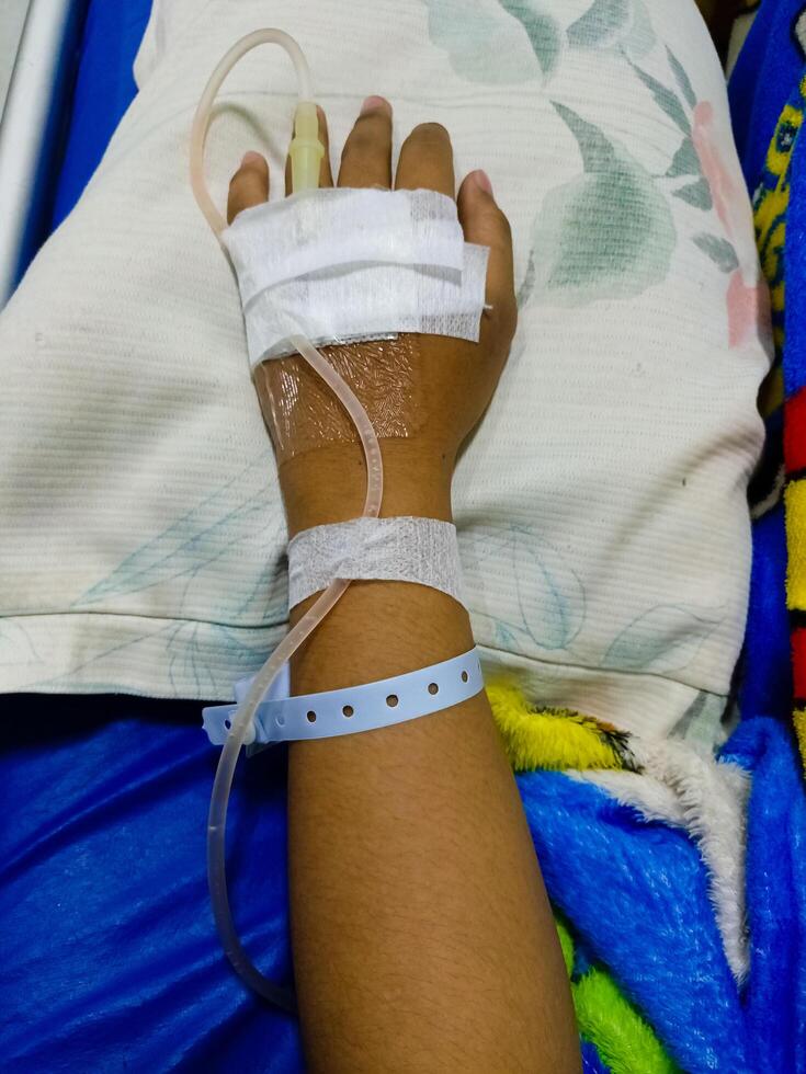 Asian man in hospital with intravenous saline. hand is being infused, infected with the virus, are lying and being treated in beds in hospitals. photo