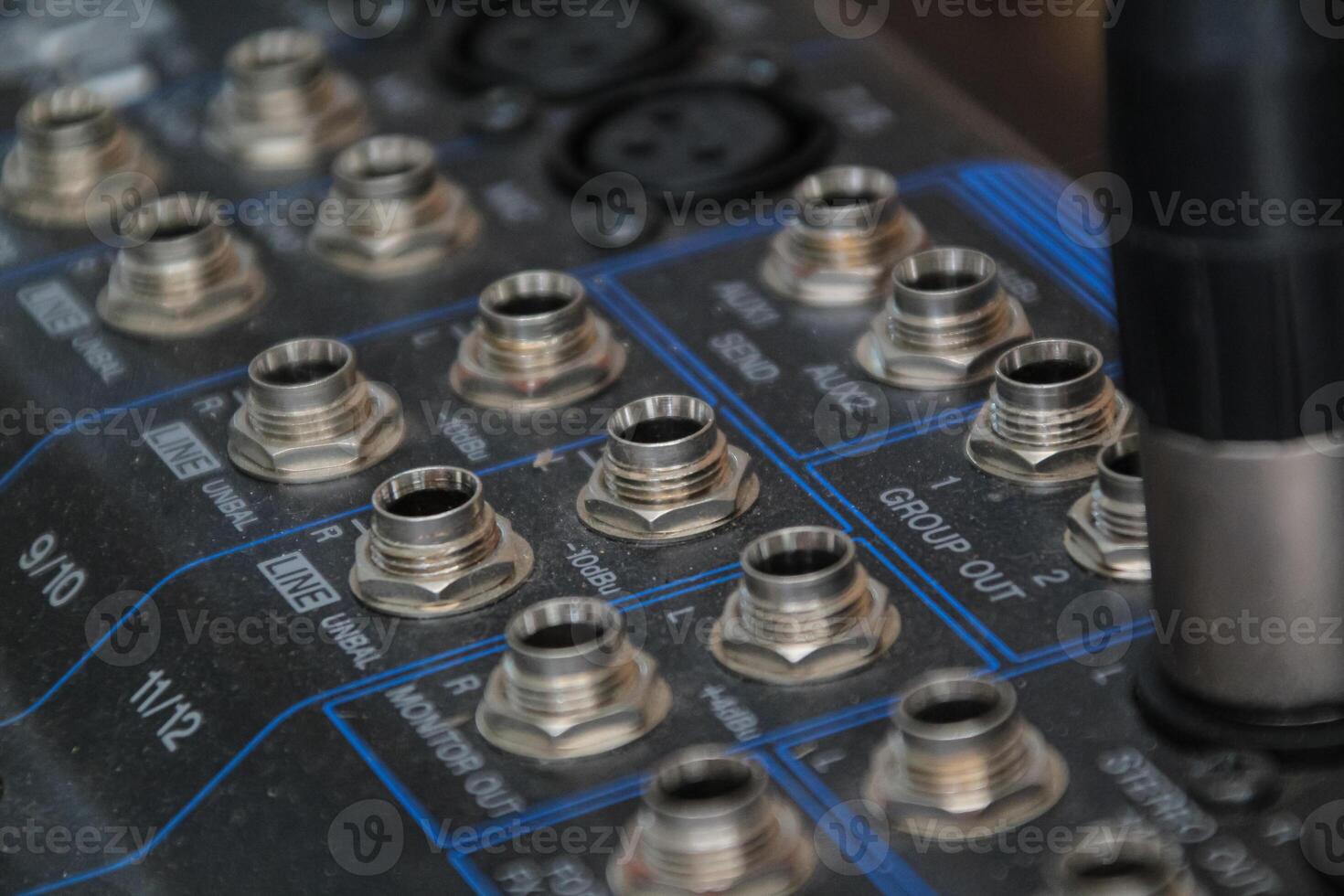 row of silver gold audio input connectors, on a professional audio mixing console or desk photo