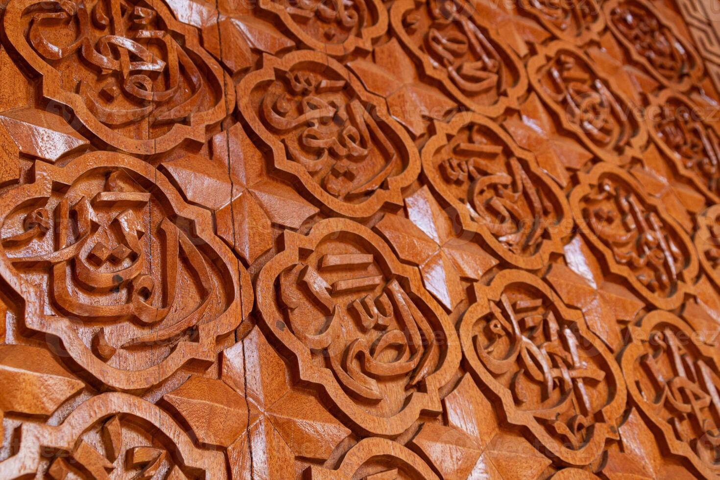 Arabic calligraphy of Allah's names in wood carvings, mosque decoration wooden doors photo
