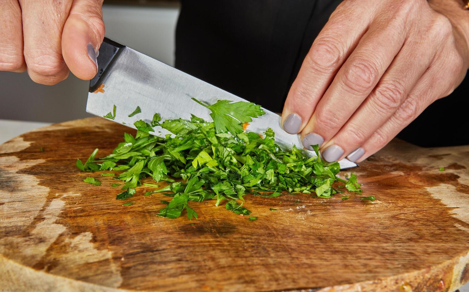 Chopping Fresh Parsley on Wooden Board photo