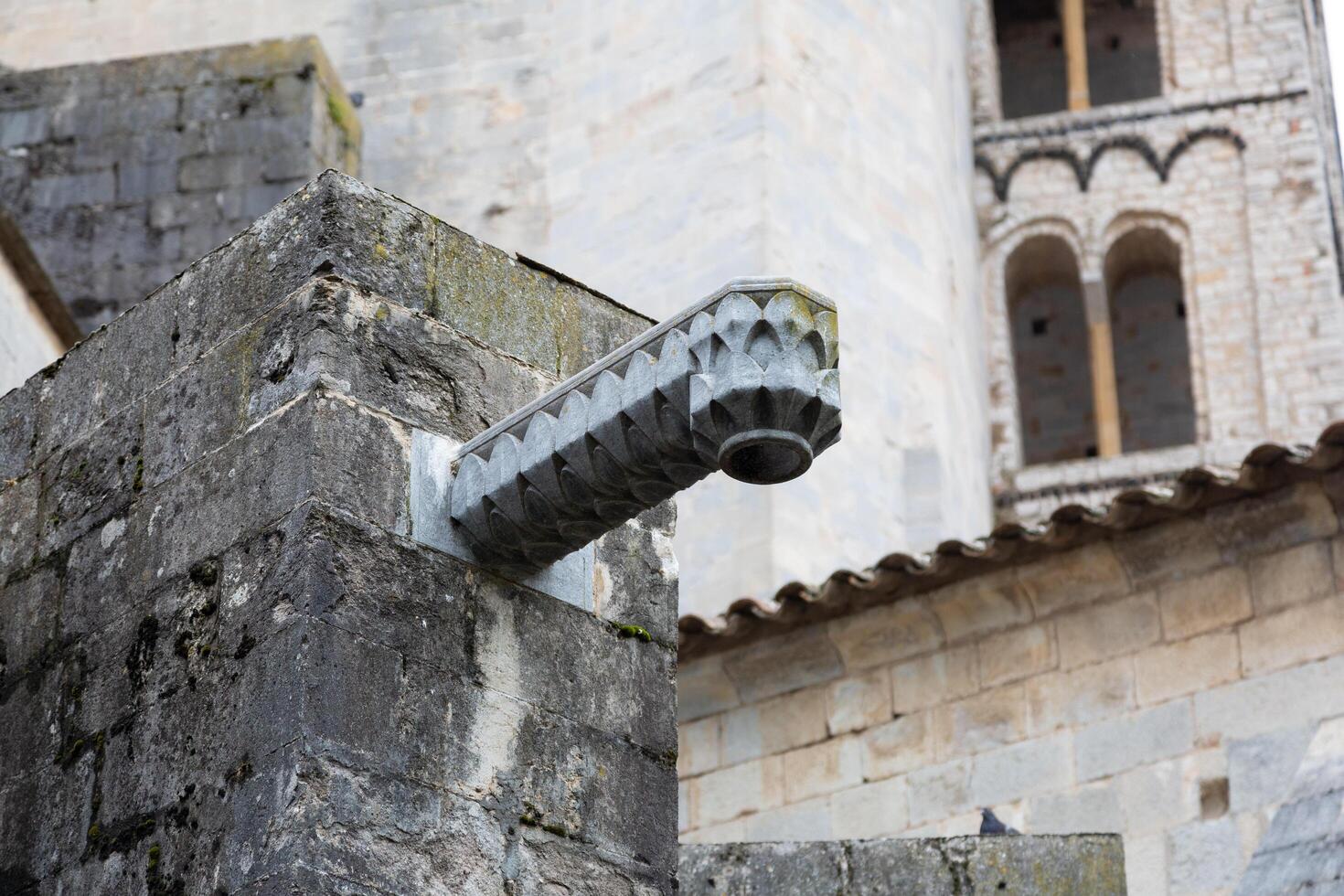 Old stone gargoyle extending out from building in europe photo