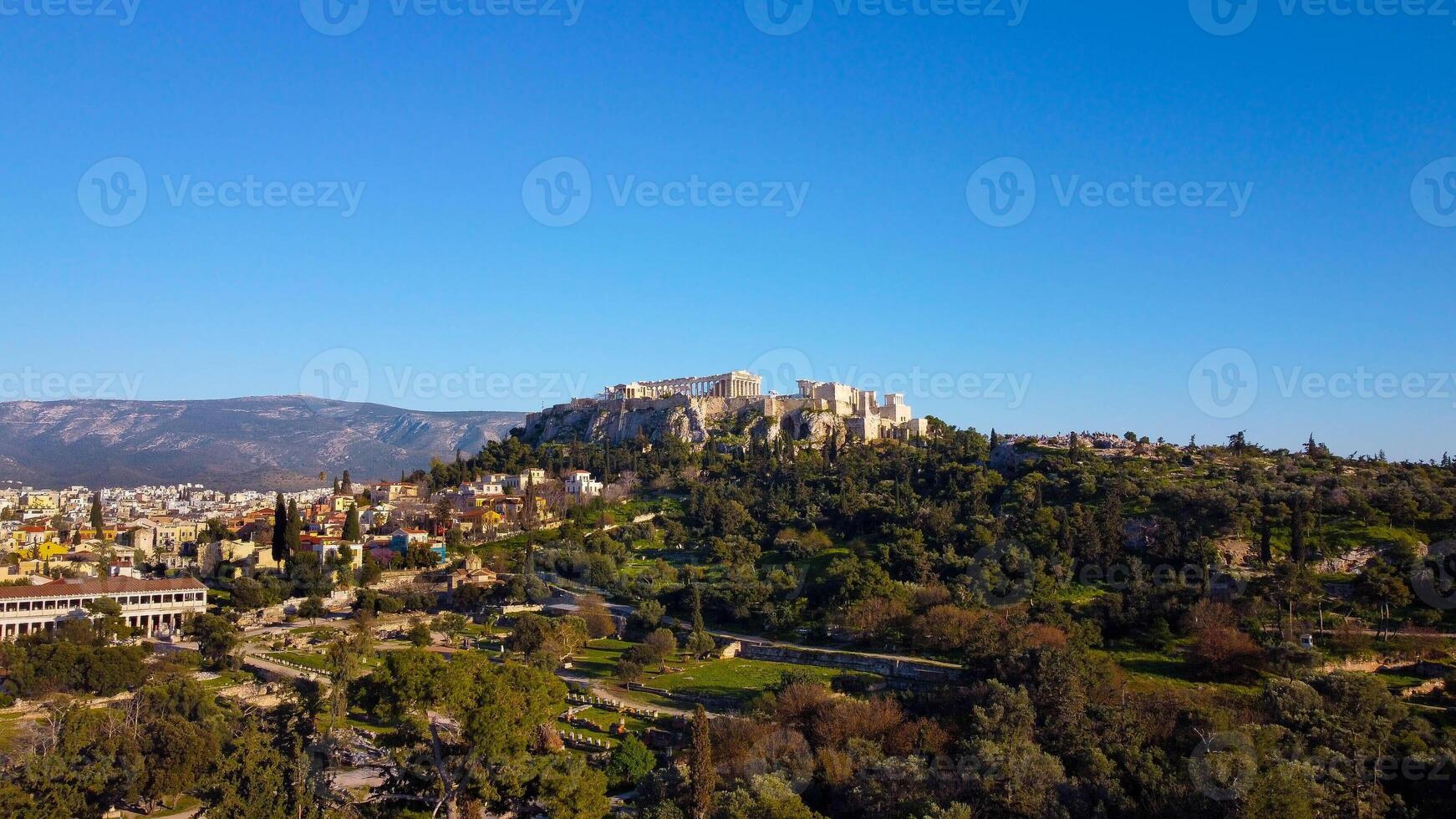 Rock of the Acropolis of Athens seen from afar. Symbol of ancient greece with blue sky background. Ancient architecture of Greek civilization. Ancient remains that attract tourists traveling in Grecce photo