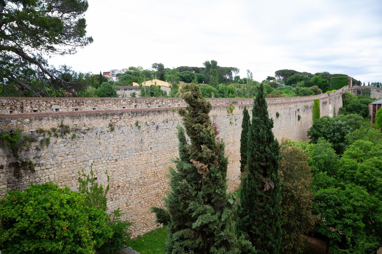 Tourists walking on top of ancient girona city wall in spain photo