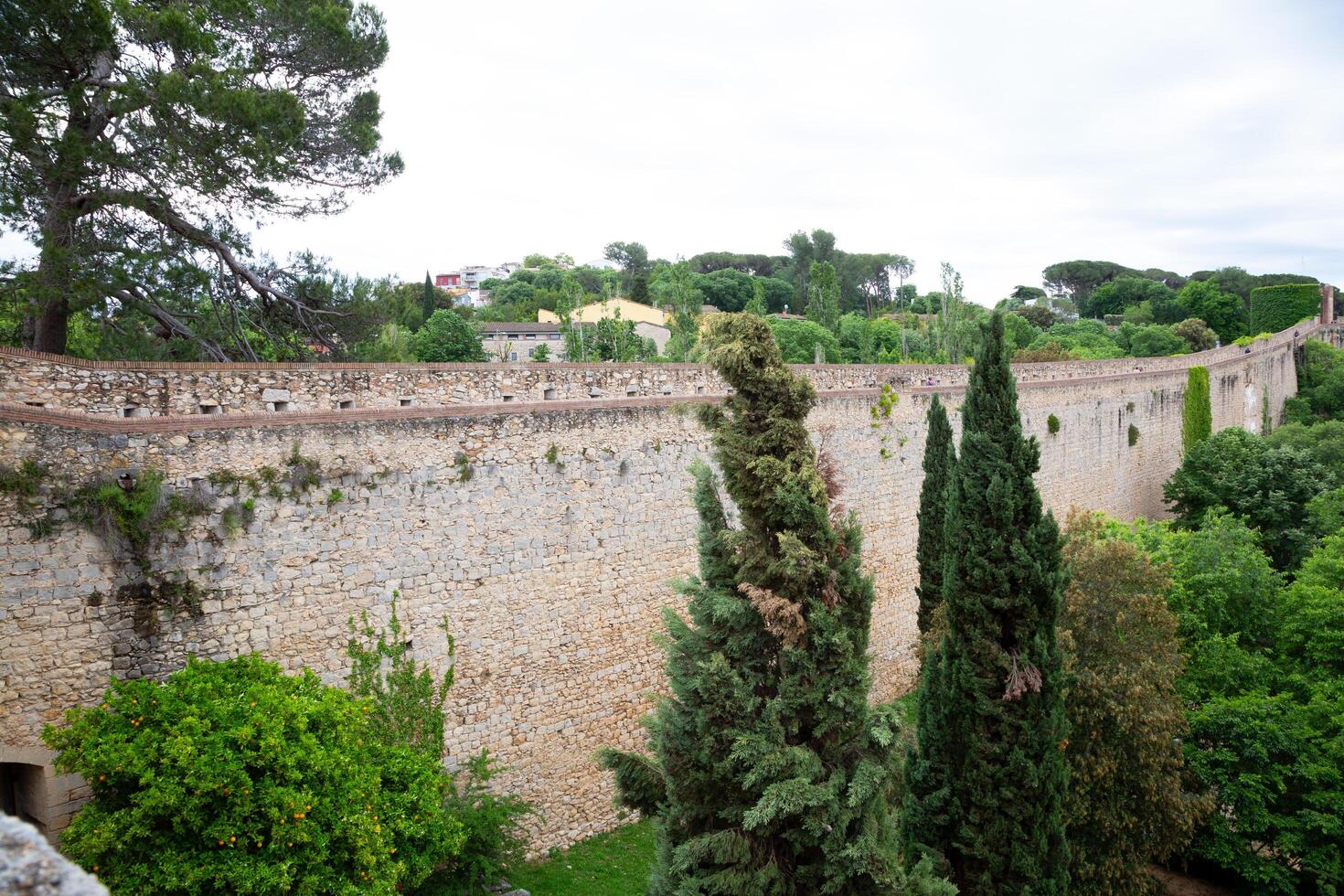 Tourists walking on top of ancient girona city wall in spain photo