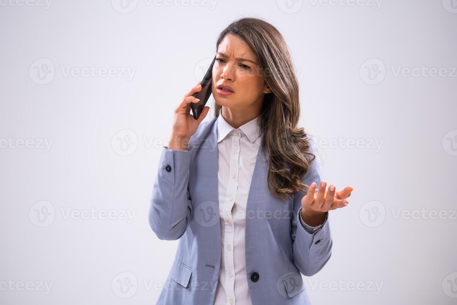Portrait of worried businesswoman who is talking on smartphone. photo