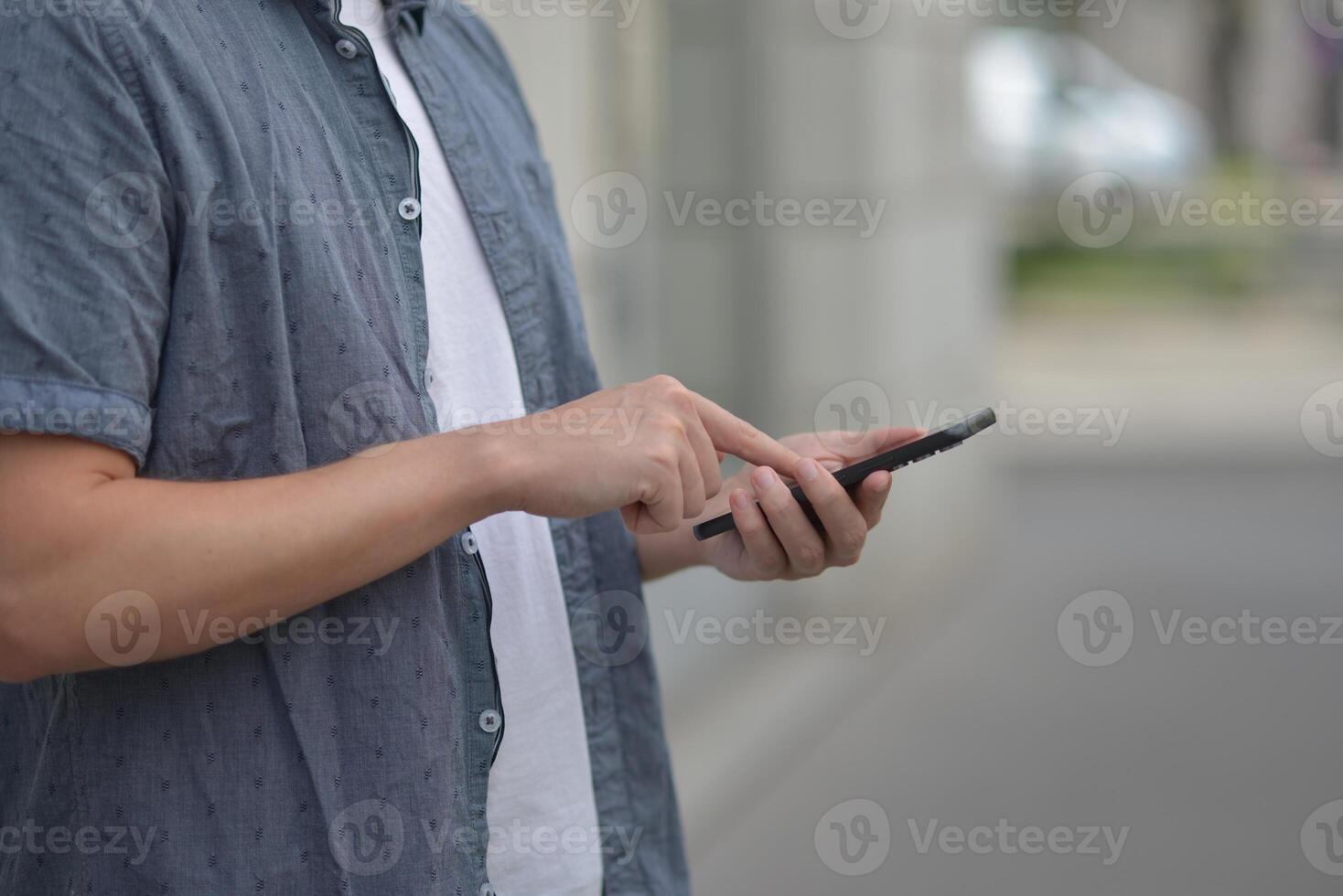A man on the street using a smartphone. Mobile phone in hands close-up. photo
