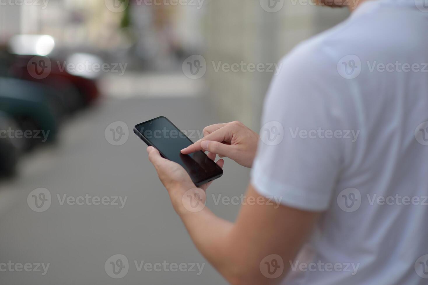 A man on the street using a smartphone. Mobile phone in hands close-up. photo