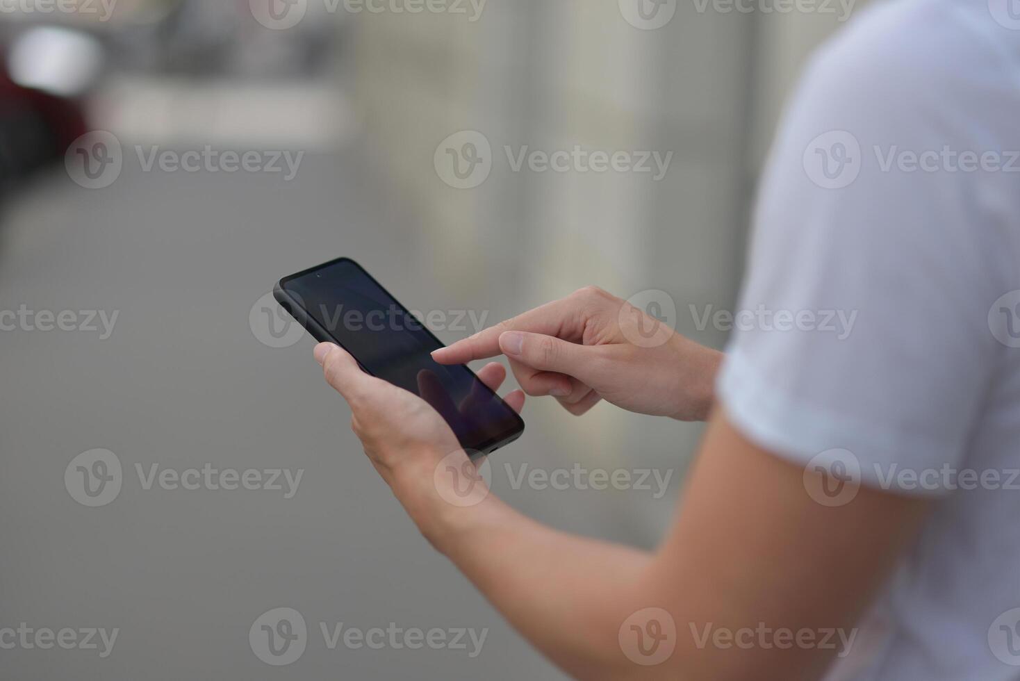 A man on the street using a smartphone. Mobile phone in hands close-up. photo