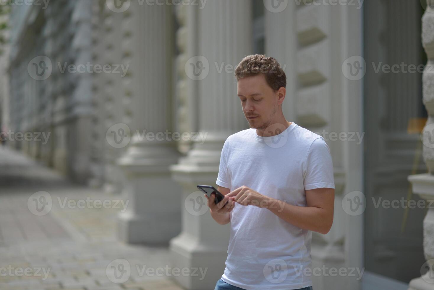 A man on the street using a smartphone. Concept of communication in social networks and messengers. photo