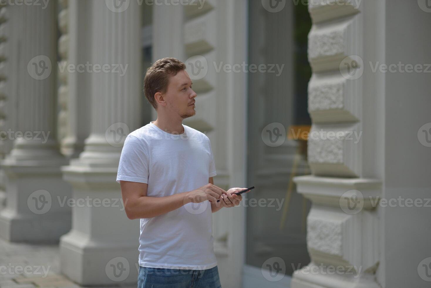 A man on the street using a smartphone. Concept of navigating in the city and using mobile maps. photo