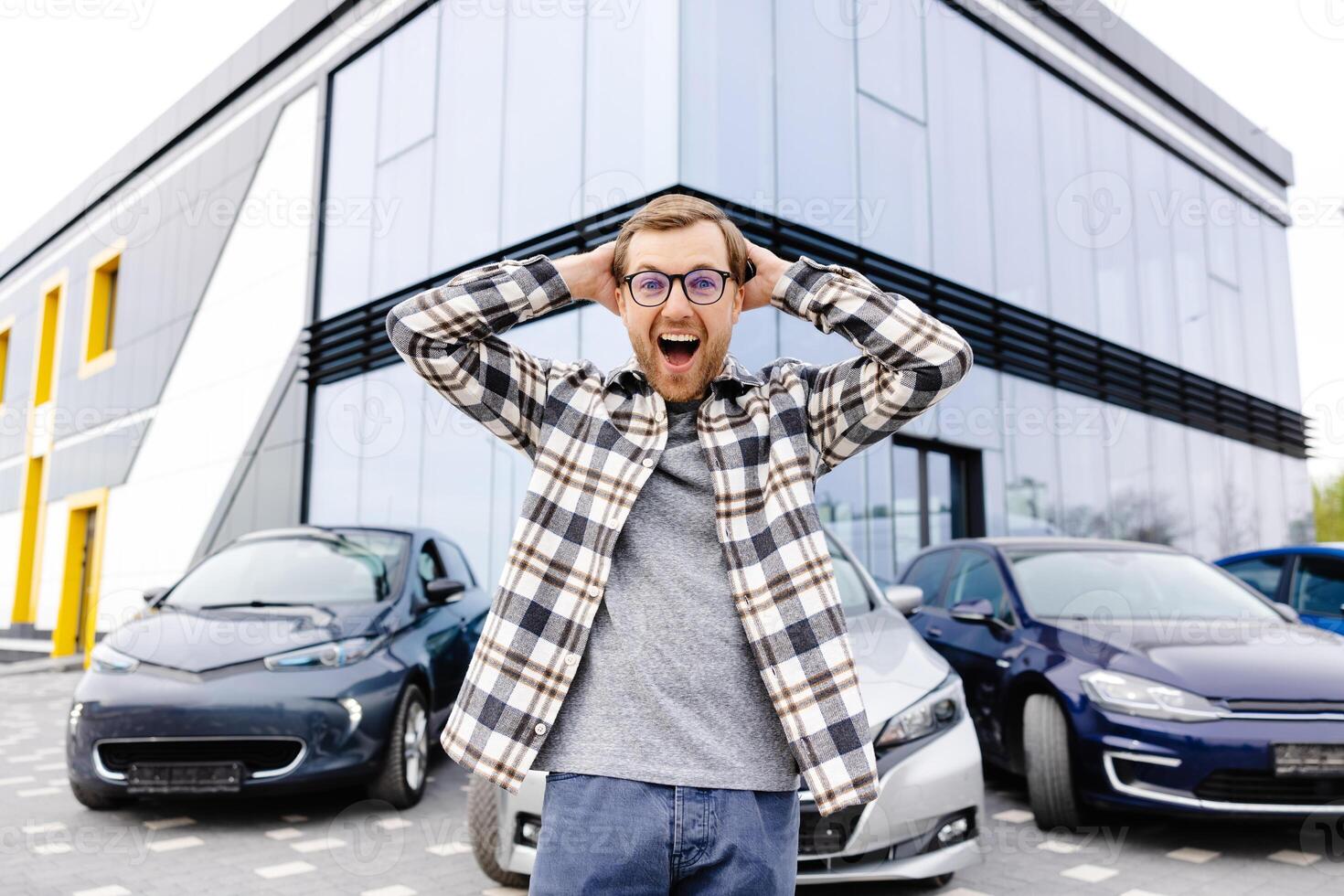A young man is very impressive and happy, standing in front of his new car photo