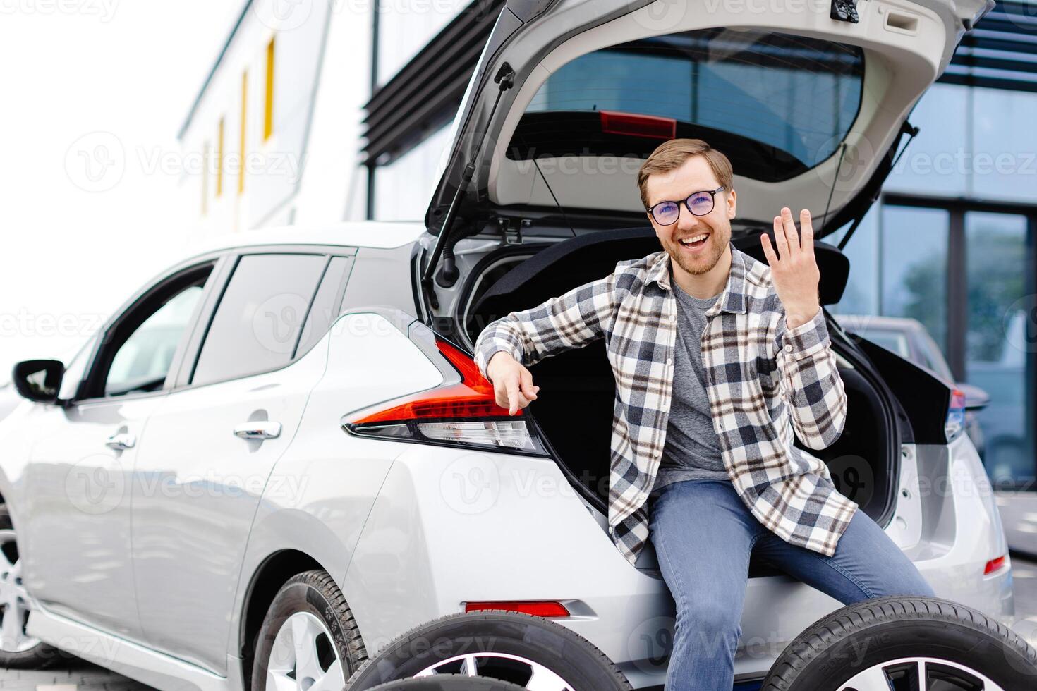 Car mechanic working in car showroom and changing wheel alloy tire. Repair or maintenance auto service. photo