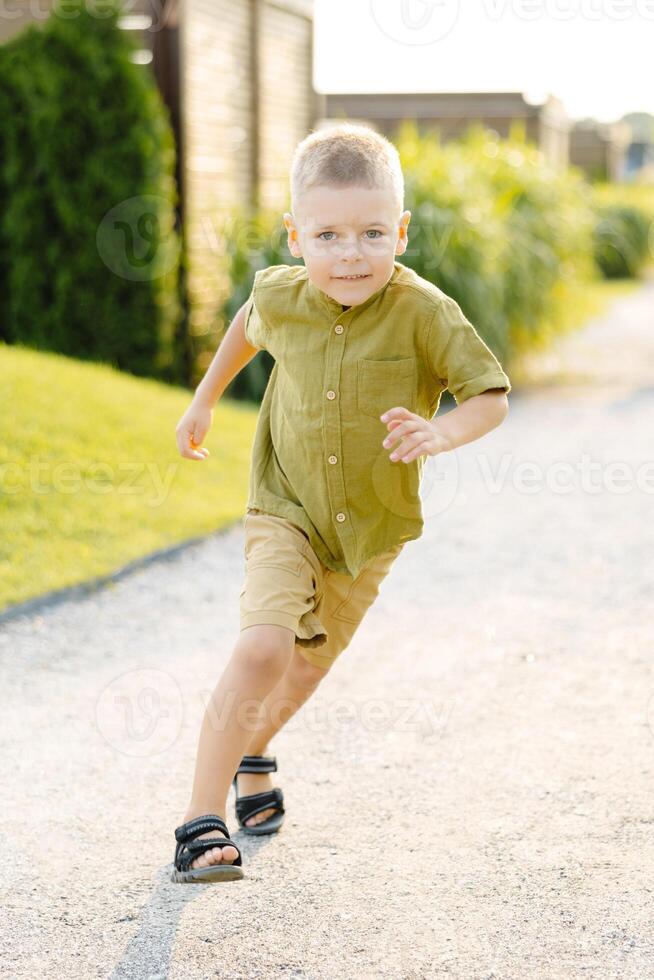 A Young Boy Joyfully Sprinting Down a Dusty Gravel Path on a Scorching Summer Day, His Laughter Echoing Through the Air photo