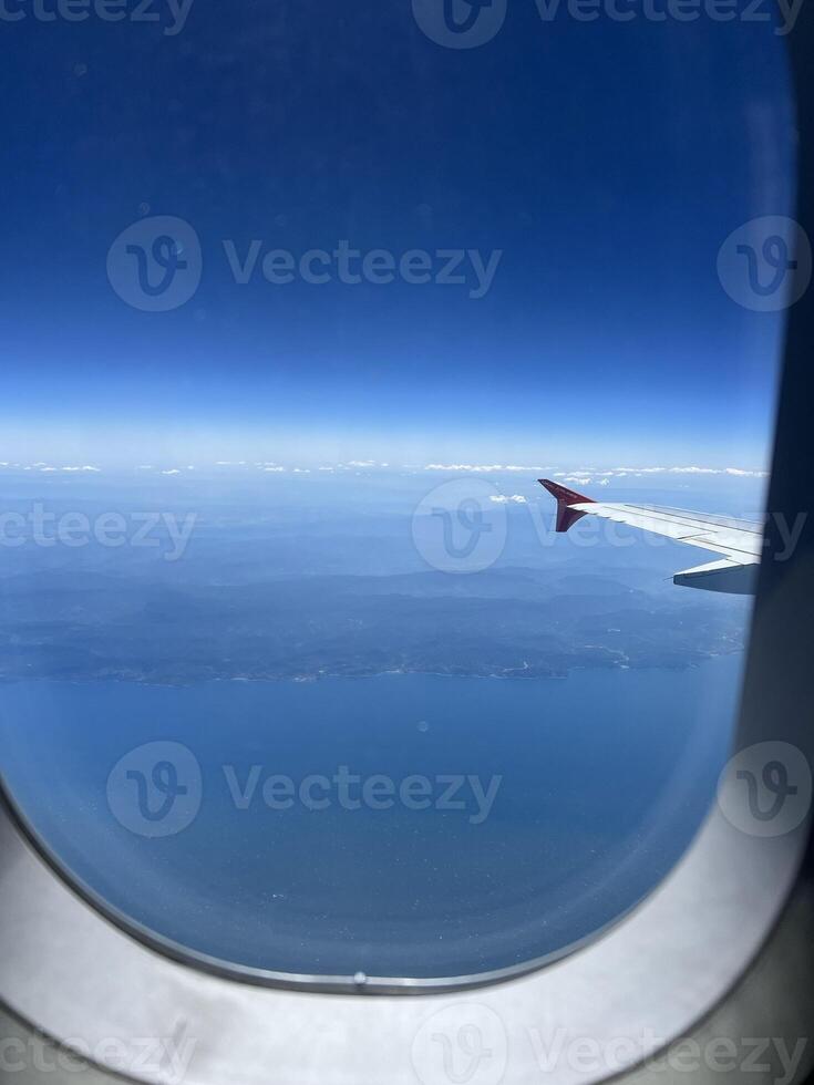 View from the airplane window of Turkey and the Black Sea coast. Wonderful panorama above white clouds as seen through window of an plane. Traveling by air concept. Selective focus. photo