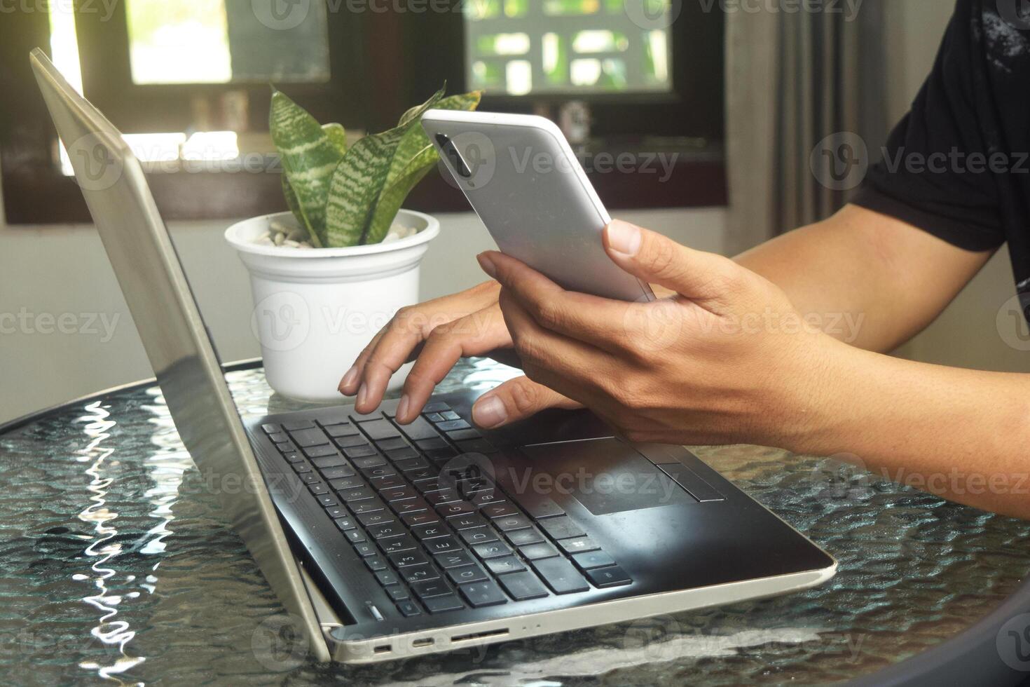 Someone is using mobile banking and a laptop photo