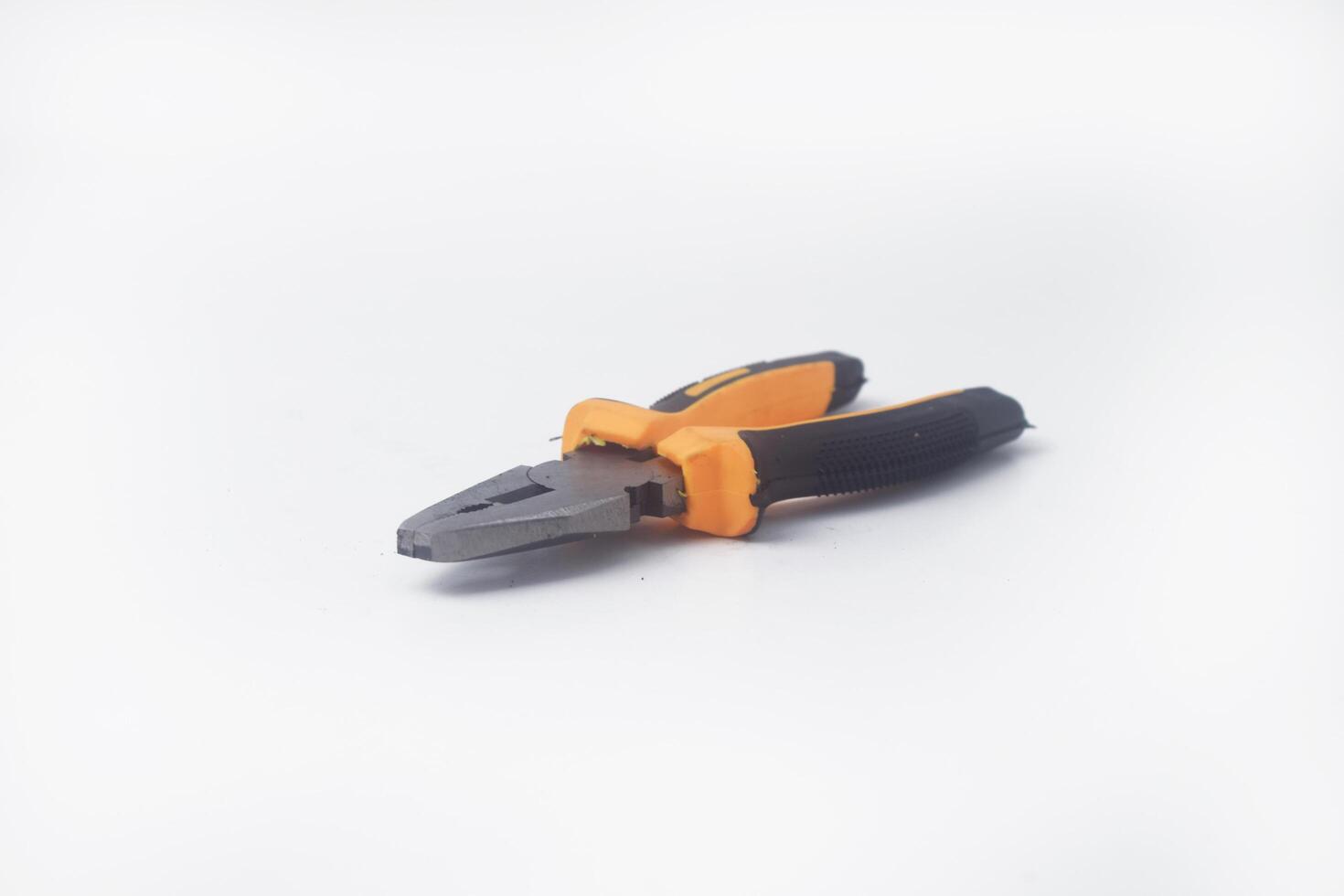 The photo from the side a pair of pliers with a yellow handle