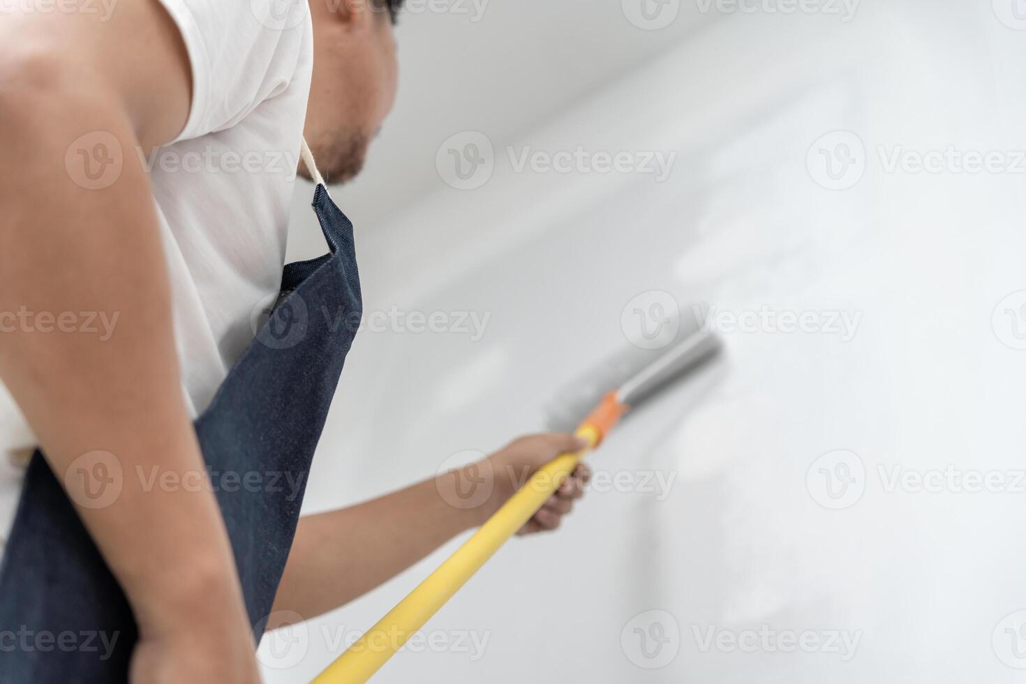 painter man, brush in hand for products to restore and paint the wall, indoor the building site of a house, wall during painting, renovation, painting, contractor, Architect, construction worke photo