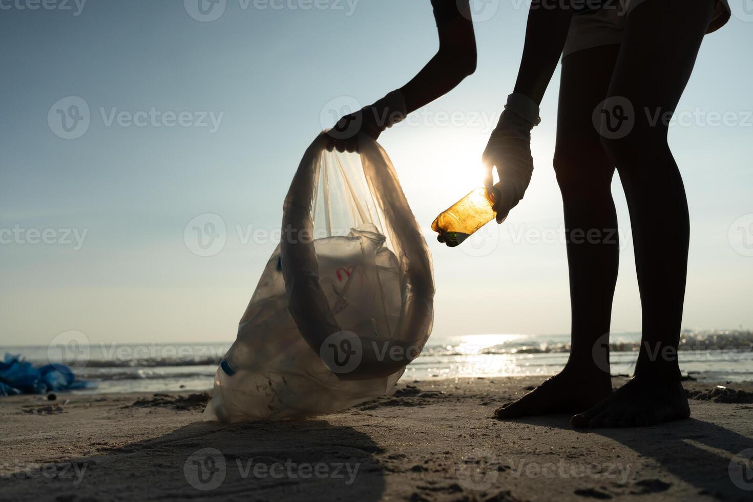 Save water. Volunteer pick up trash garbage at the beach and plastic bottles are difficult decompose prevent harm aquatic life. Earth, Environment, Greening planet, reduce global warming, Save world photo