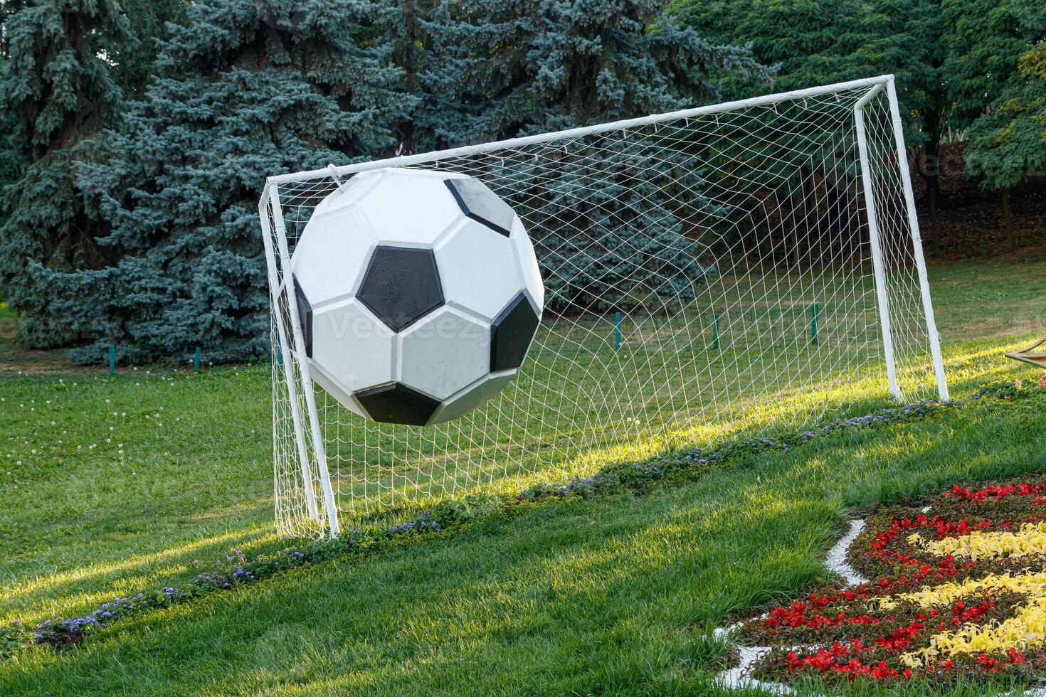 Soccer goal on grass and big ball photo