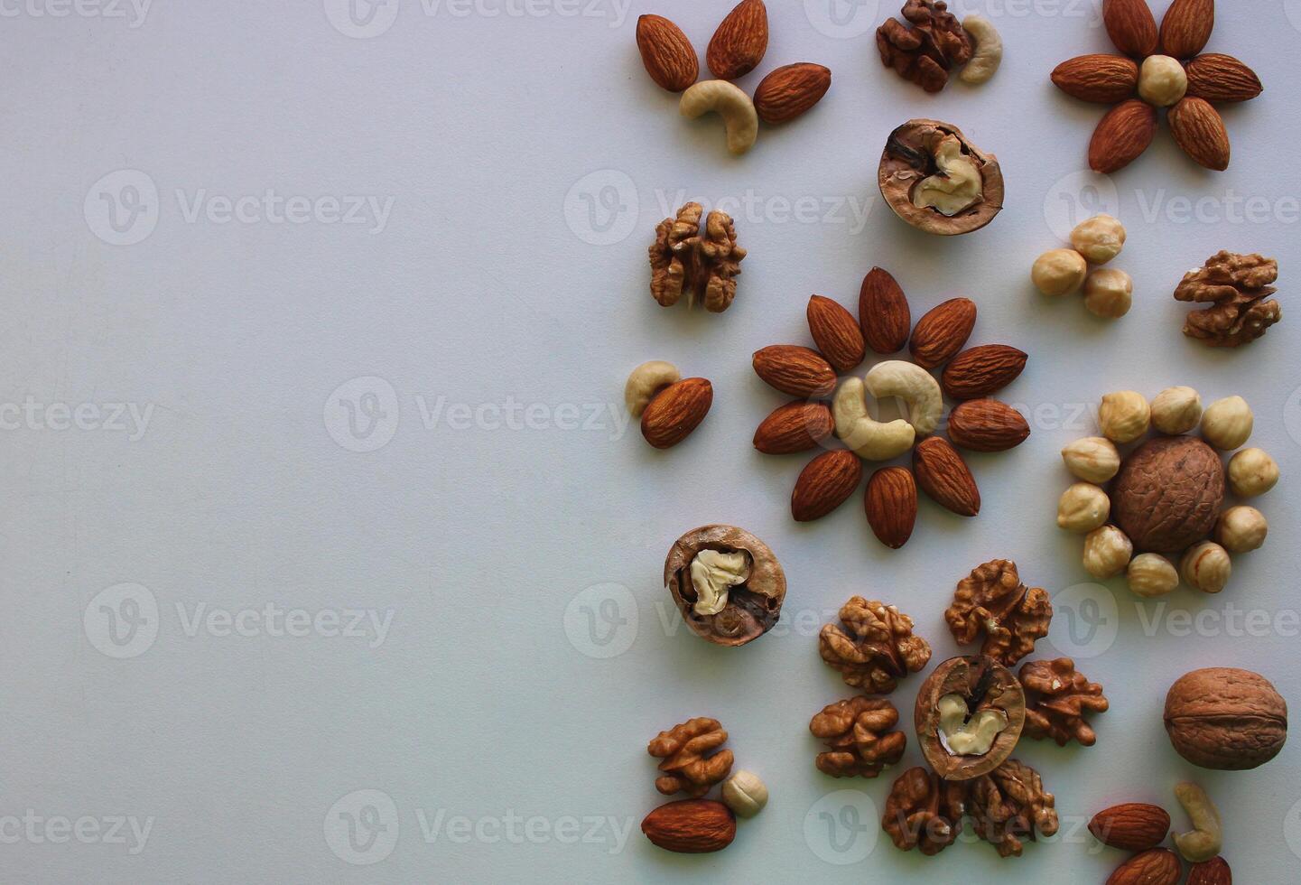 Half of the image is hidden by a mix of clean dried kernels nuts in a shape of flowers photo