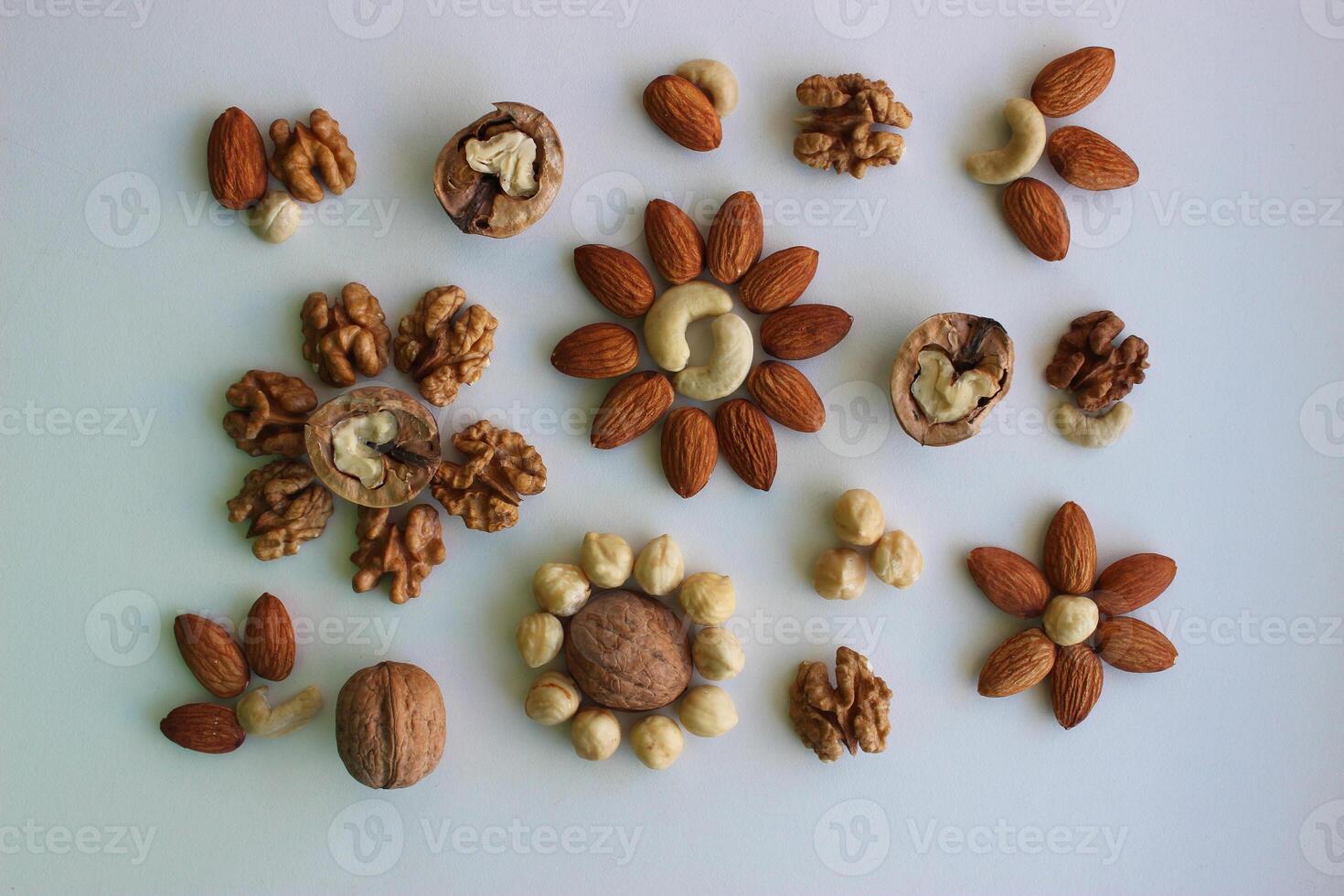 Pattern Of Almonds, Hazelnuts, Cashew And Walnuts Laid Out In A Shape Of Flowers Top View photo