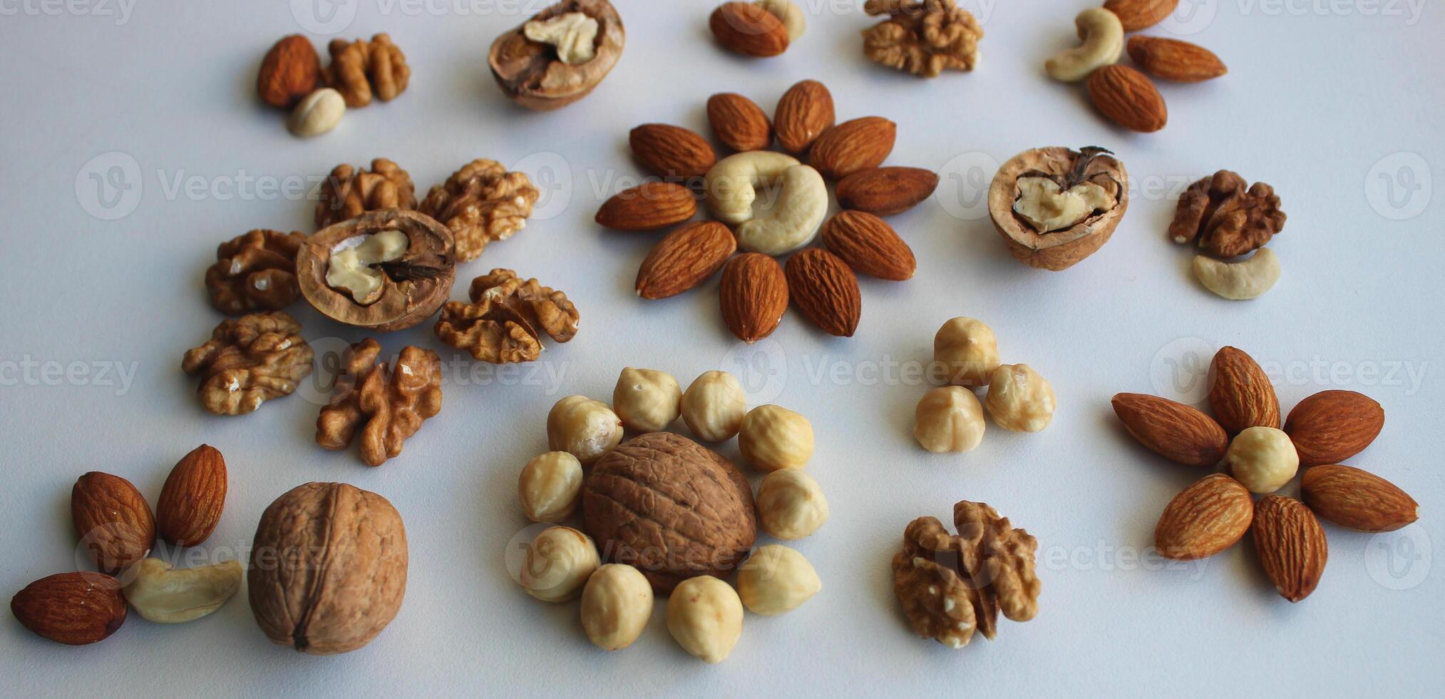 Flowers Pattern made of laid out nuts of different varieties on a white background concept for backgrounds photo