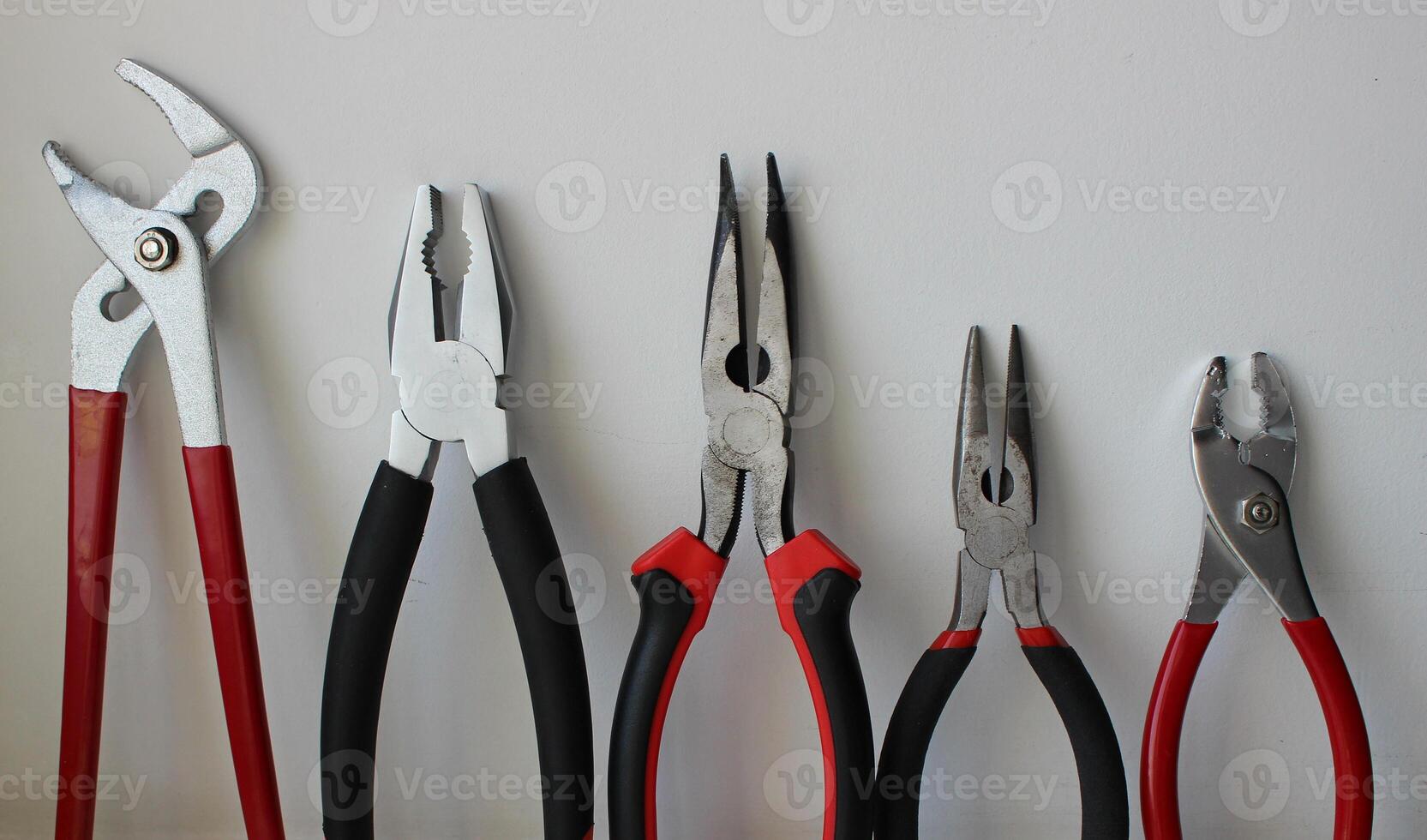 Different Types Of Pliers With Plastic Handles Arranged By Size Isolated On White Background photo
