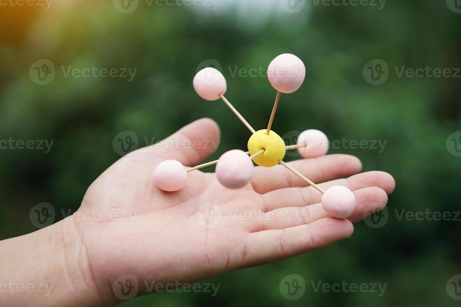 Closeup hand hold DIY molecule structure made from toothpicks and plasticine for teaching. Concept, teaching aids, educational materials. science lesson about molecule. Creative task from learning. photo