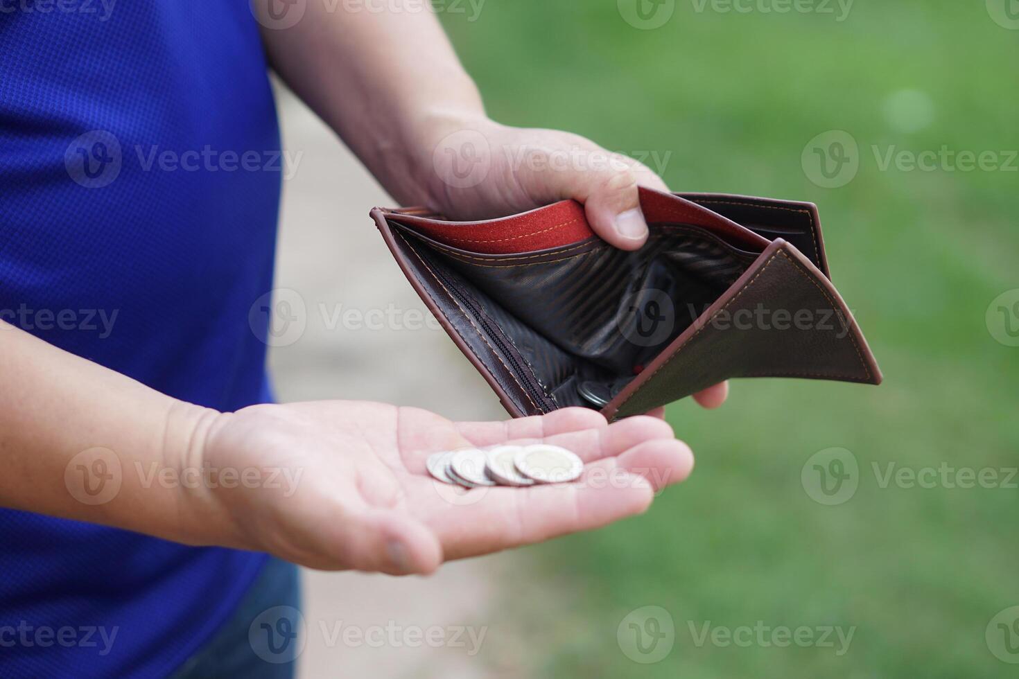 Poor man hold leather wallet with some coins. Concept bad economy, financial crisis, risk on the end of month. Finance management. Pay day. Debt. Broke. Bankrupt. Financial problems. photo