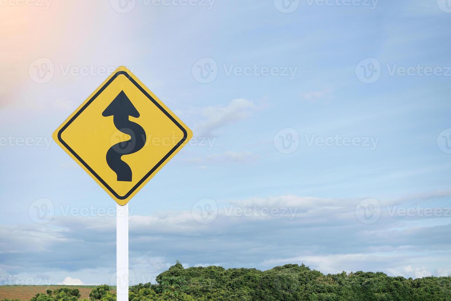 Curved road traffic yellow sign. Warning attention sign Left Winding Road. Concept, Warning traffic sign for Giving direction for transportation and way to go. photo
