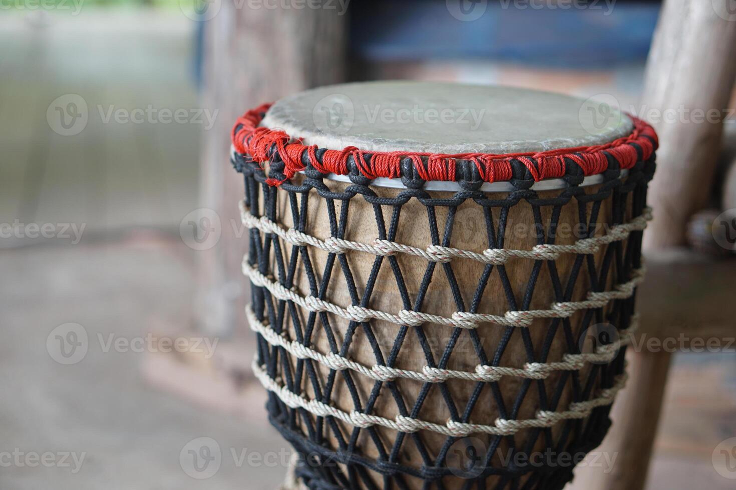 Folklore drum, decorated with rope knots net. Concept, musical instrument. Beat drum with rhythm along music and songs for entertainment. Vintage and traditional style. Hand drum. photo