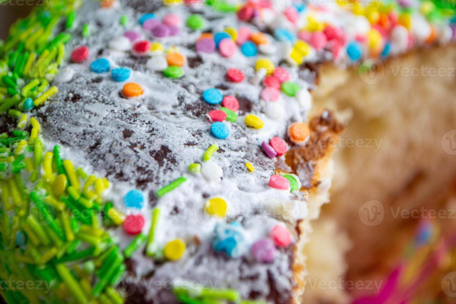 A cake with sprinkles on it is decorated with colorful sprinkles. photo