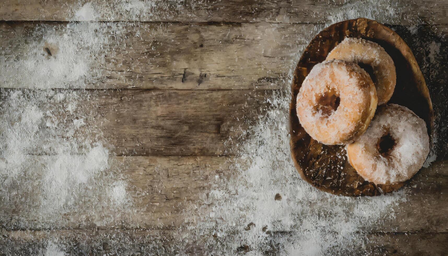 Copy Space image of Donuts with powdered sugar on wooden table on black background photo