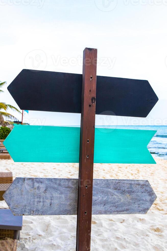 Black grey turquoise blank arrow signs for labeling on beach. photo