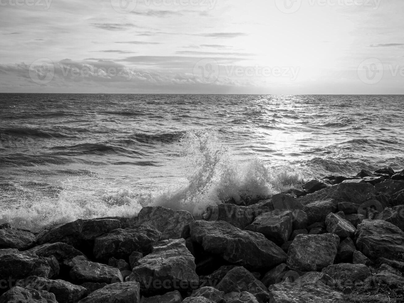 Beautiful sea waves with foam and sky, front view. Monochrome image photo