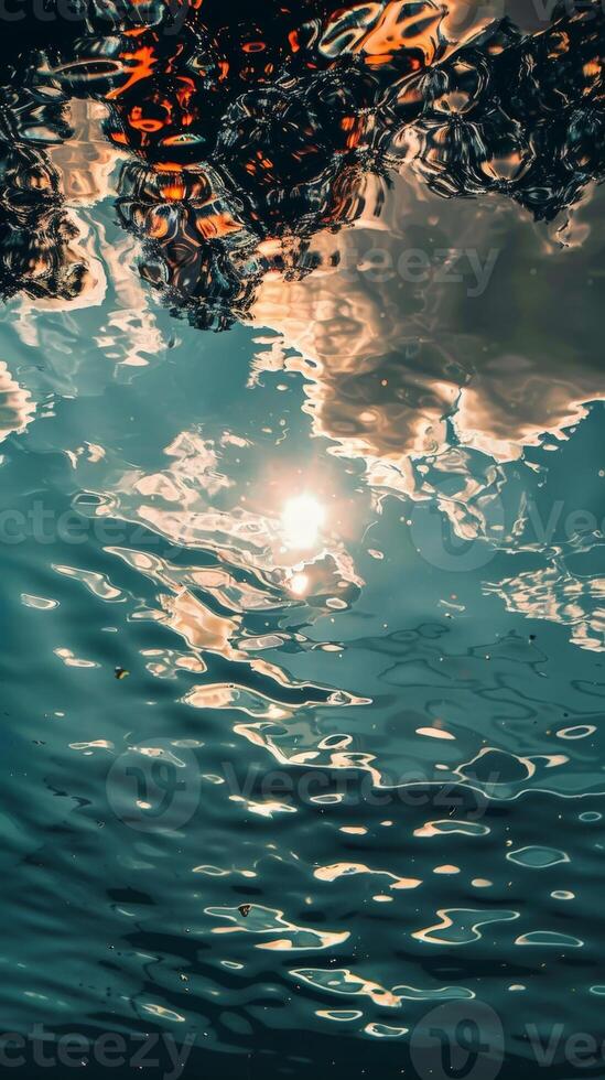 Sunbeams shimmer through the water, illuminating clouds above photo