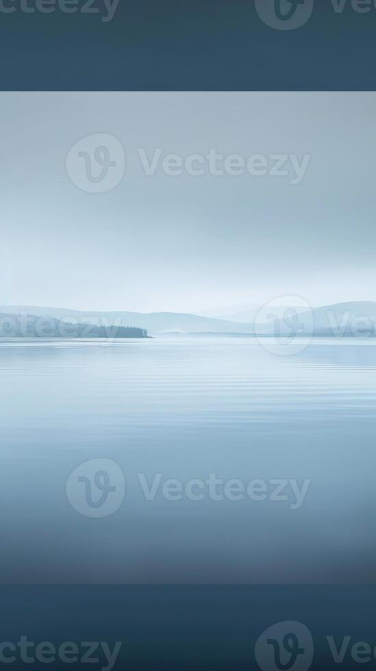 A still lake with a soft, misty fog rolling across the water photo