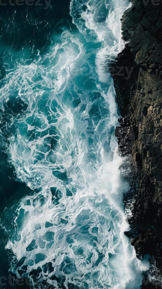 Ocean waves crashing against the shore, creating a swirling pattern of foam photo