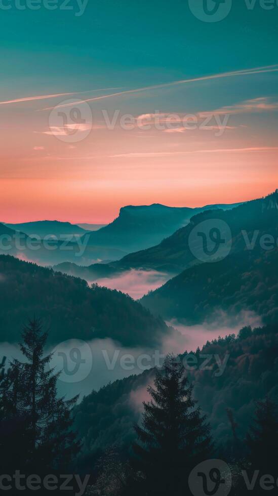 Misty mountain landscape with a soft, pink sunset sky photo