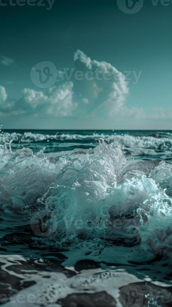 Ocean waves crest and foam under a teal sky photo