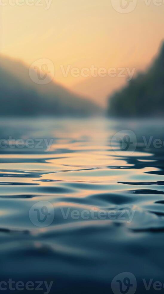 A close-up of rippling water, reflecting the soft glow of a setting sun photo