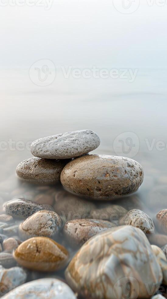 Smooth, wet stones on the edge of a tranquil lake photo
