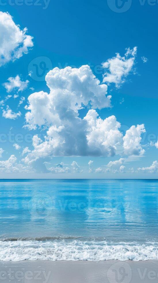Serene beach with calm, crystal-clear water and puffy clouds overhead photo