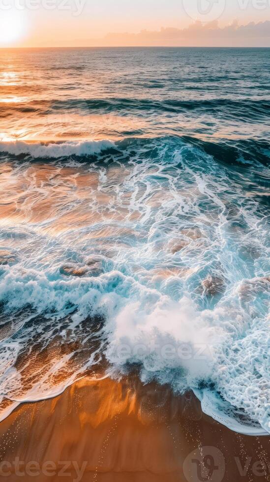 Waves breaking on a sandy beach at sunset, golden light photo