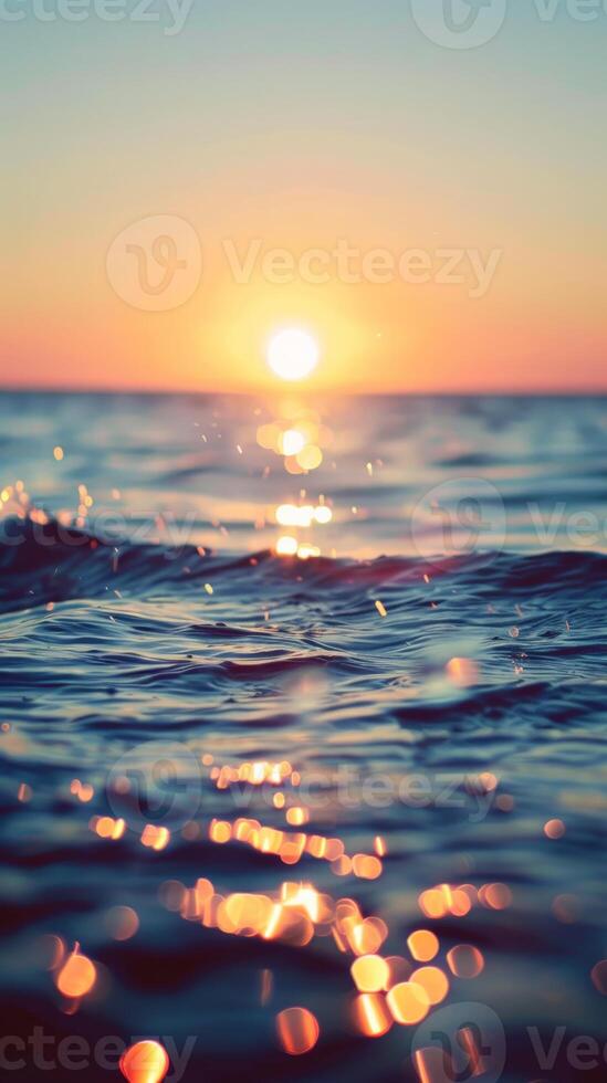 A golden sunset casts shimmering reflections on the surface of the ocean waves photo