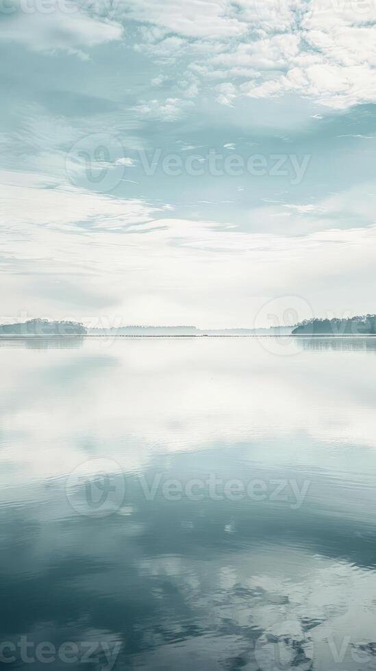 A serene lake reflecting the clouds and sky above photo