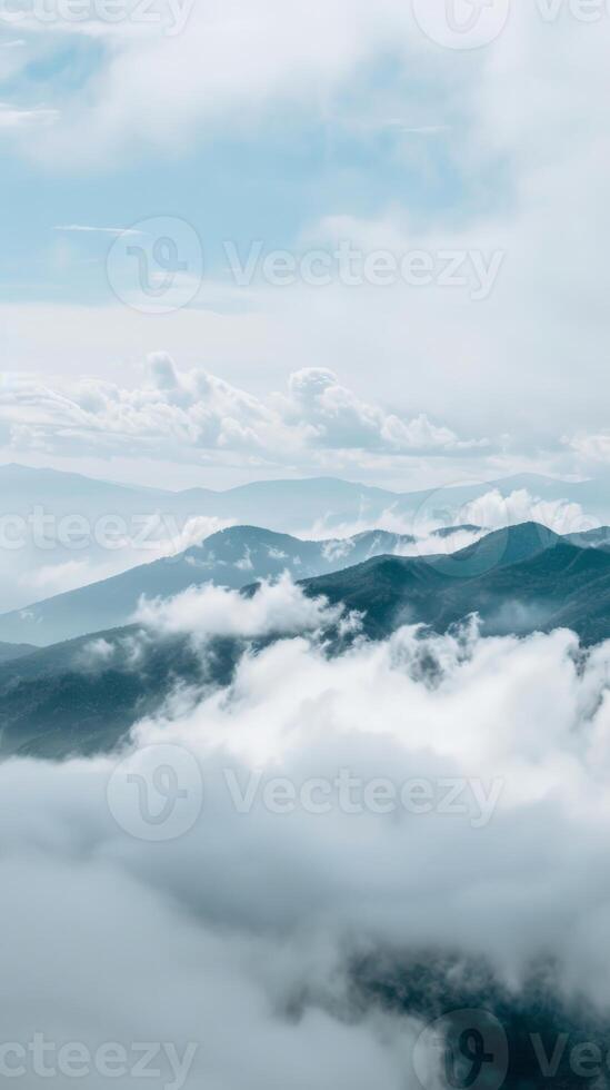 A serene view of mountains breaking through a sea of clouds photo