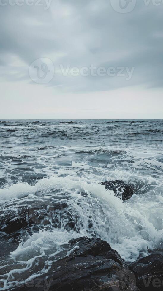 Waves break on the rocky shore, creating a dramatic scene photo