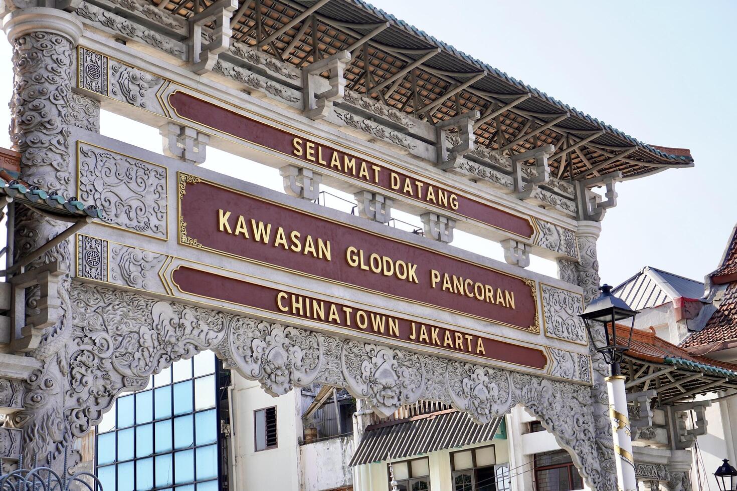 Jakarta, Indonesia - July 17th, 2024 - Kawasan glodok pancoran chinatown jakarta gate entrance landmark architecture design isolated on horizontal city buildings exterior and bright sky background. photo