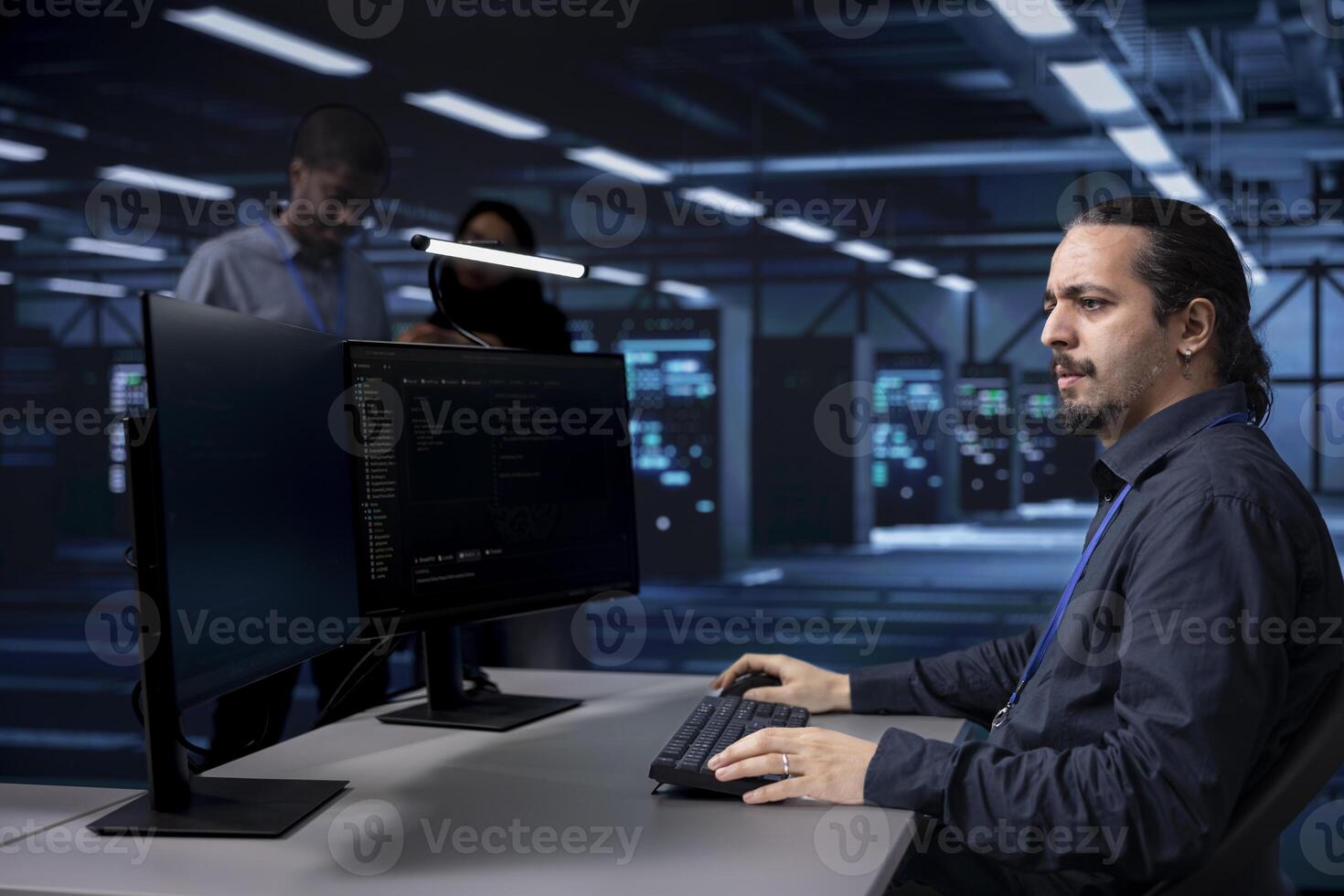 Programmer typing on PC in data center, updating systems to protect servers from exploitable software vulnerabilities. IT expert coding and looking for errors causing equipment to slow down photo